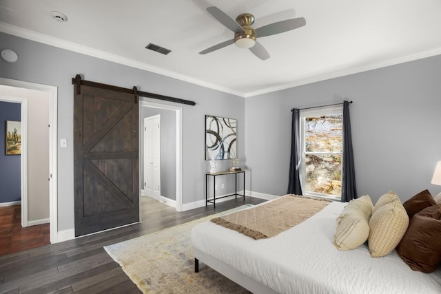 bedroom featuring visible vents, ornamental molding, a barn door, and wood finished floors