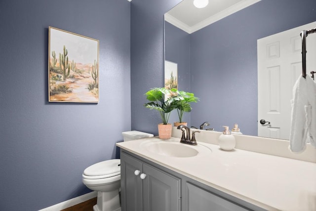 bathroom with toilet, vanity, baseboards, and ornamental molding