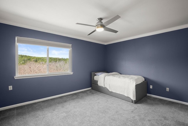 unfurnished bedroom with ornamental molding, a ceiling fan, baseboards, and carpet floors