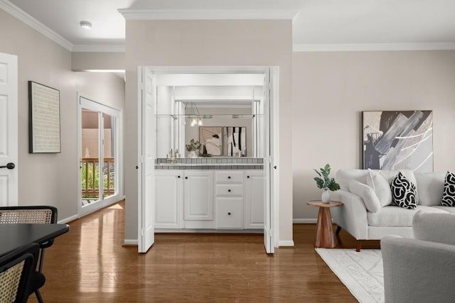 living room featuring dark wood-type flooring, baseboards, and ornamental molding