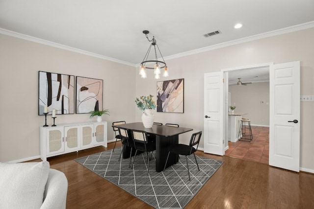 dining area with visible vents, crown molding, baseboards, and dark wood-style flooring