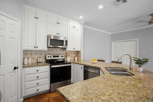 kitchen featuring visible vents, ornamental molding, a sink, backsplash, and appliances with stainless steel finishes