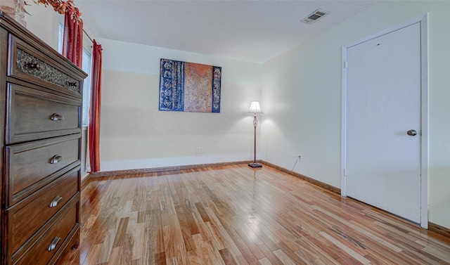 unfurnished bedroom with light wood-style floors, visible vents, and baseboards