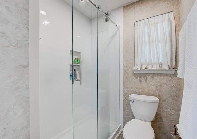 bathroom with a shower stall and toilet