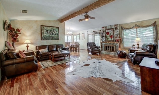 3604 Tamarack Trl, Austin, TX 78727 - living room with wood finished floors, a chandelier, ceiling fan, a fireplace, and beamed ceiling