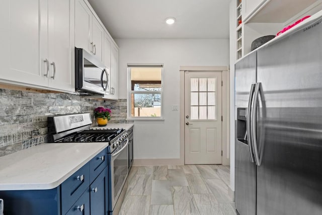 kitchen featuring stainless steel appliances, decorative backsplash, light countertops, white cabinetry, and blue cabinets