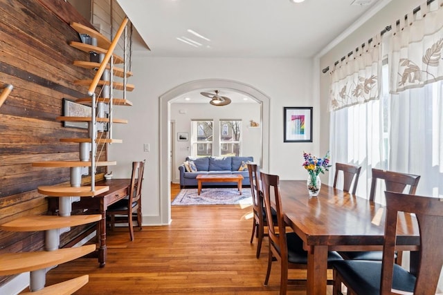 dining space featuring wood finished floors and arched walkways