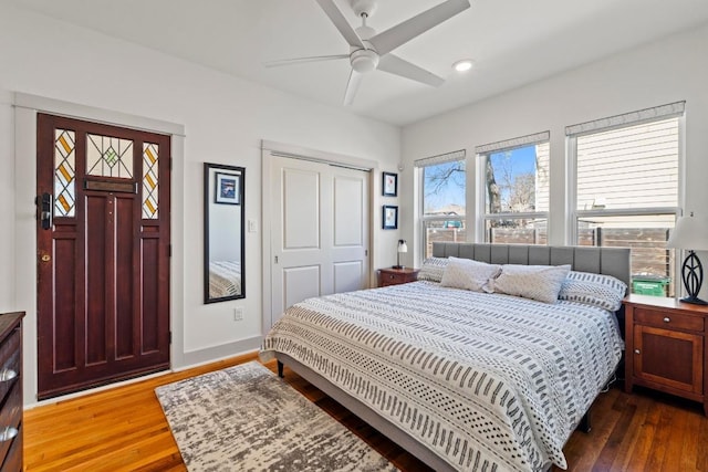 bedroom featuring a ceiling fan, wood finished floors, baseboards, recessed lighting, and a closet