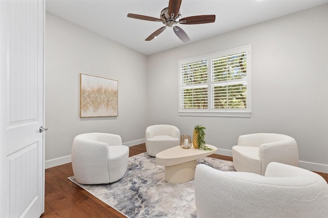 living area featuring ceiling fan, baseboards, and wood finished floors