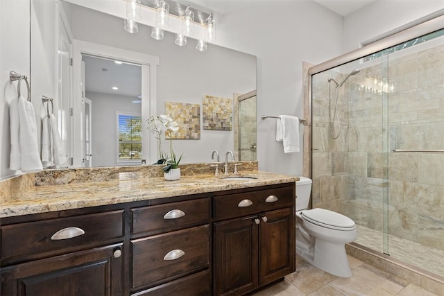 full bathroom featuring a stall shower, toilet, vanity, and tile patterned flooring