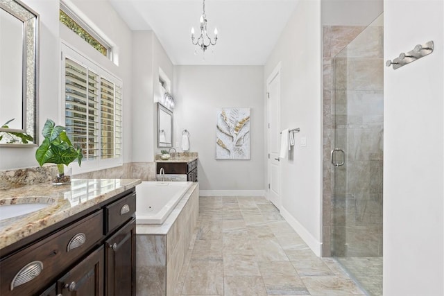 full bathroom with baseboards, two vanities, a shower stall, a garden tub, and a notable chandelier