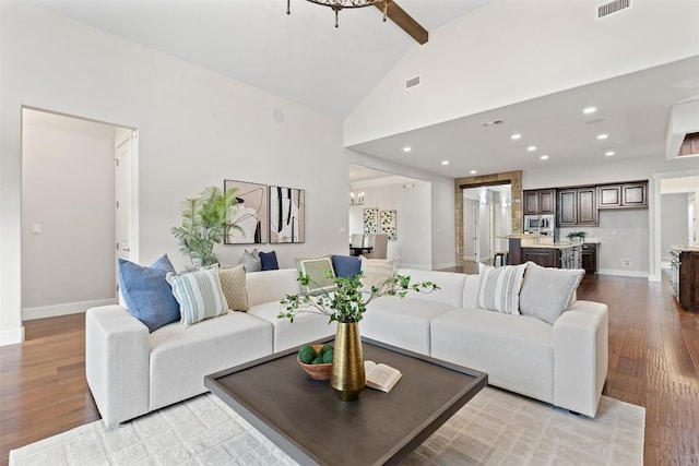 living room featuring visible vents, high vaulted ceiling, an inviting chandelier, and wood finished floors