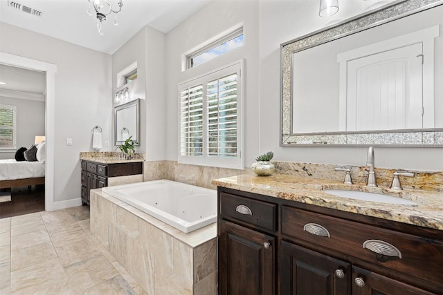 bathroom with a jetted tub, connected bathroom, two vanities, and baseboards
