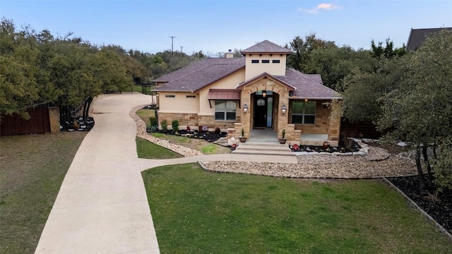 view of front facade featuring stone siding, roof with shingles, a front lawn, and fence