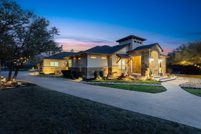 view of front of house with stucco siding, stone siding, a lawn, and a chimney