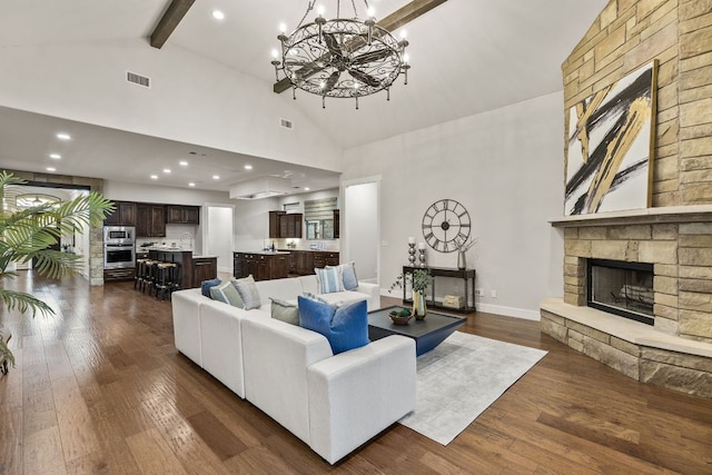 living room featuring high vaulted ceiling, a fireplace, beamed ceiling, a chandelier, and dark wood-style flooring
