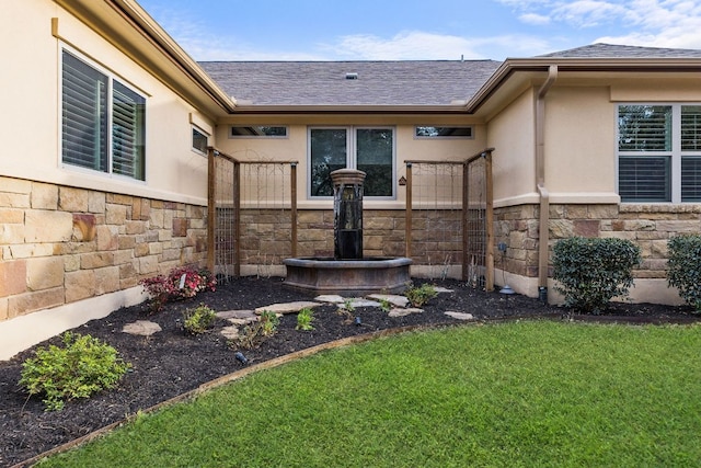 property entrance featuring stone siding, roof with shingles, a lawn, and stucco siding