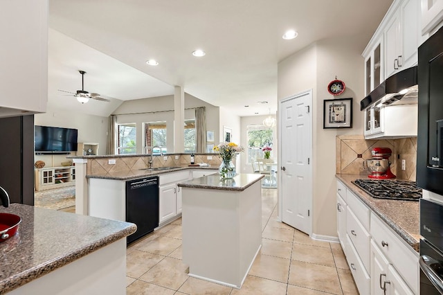 kitchen featuring a sink, a kitchen island, dishwasher, and a wealth of natural light