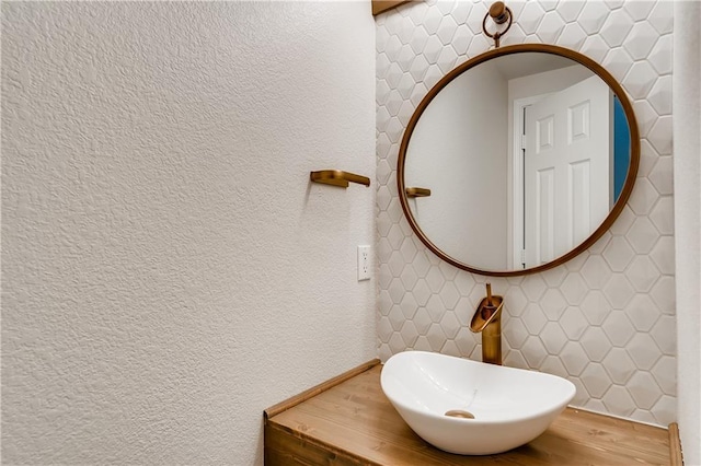 bathroom featuring a sink and a textured wall