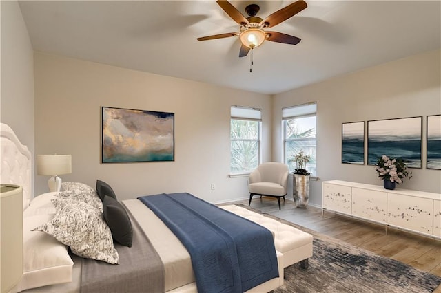 bedroom with baseboards, wood finished floors, and a ceiling fan