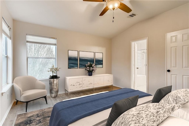 bedroom featuring visible vents, wood finished floors, baseboards, and vaulted ceiling