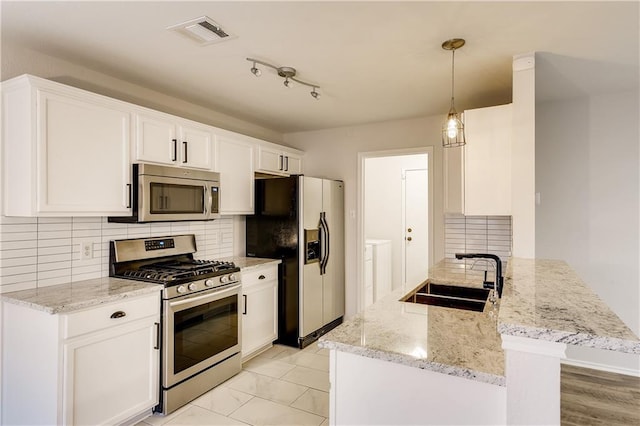 kitchen featuring visible vents, a sink, appliances with stainless steel finishes, white cabinets, and light stone countertops