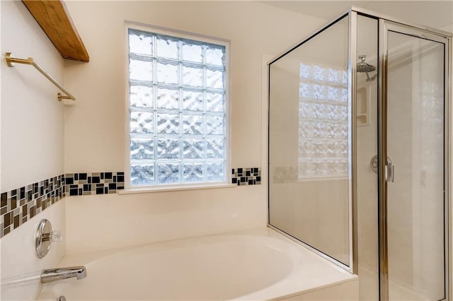 bathroom with a shower stall and a bath