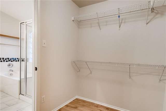 walk in closet with light wood-type flooring