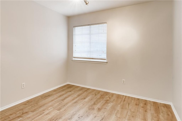 empty room with light wood-style flooring and baseboards