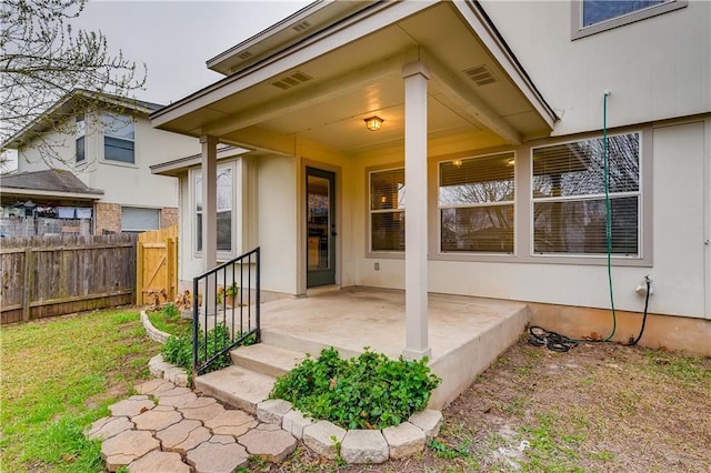 doorway to property with visible vents and fence