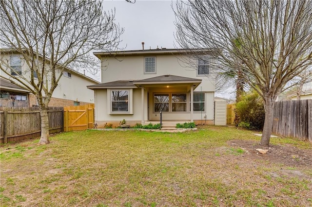 back of house featuring a yard, a fenced backyard, and stucco siding