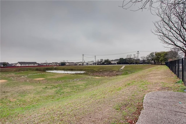 view of yard featuring fence and a water view