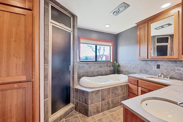 bathroom with tile patterned flooring, double vanity, a stall shower, and a sink