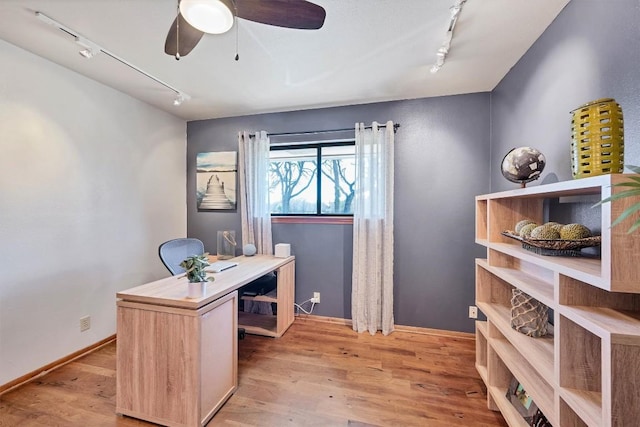 office featuring track lighting, baseboards, light wood-type flooring, and a ceiling fan