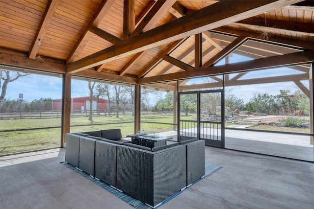 unfurnished sunroom with vaulted ceiling with beams and a healthy amount of sunlight