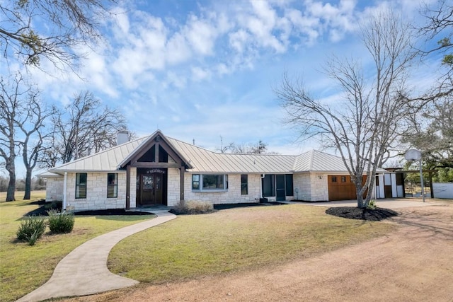 view of front of house with driveway, a standing seam roof, a front yard, an attached garage, and metal roof