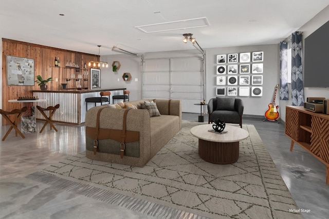 living room featuring wooden walls, concrete flooring, and a garage