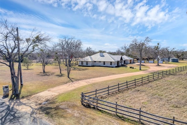 view of yard featuring a rural view, fence, and driveway