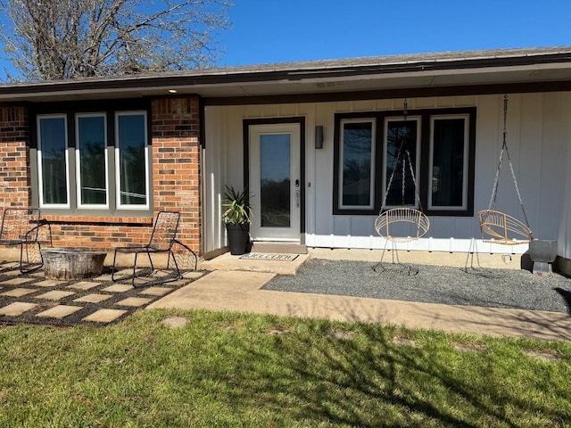 view of exterior entry featuring brick siding