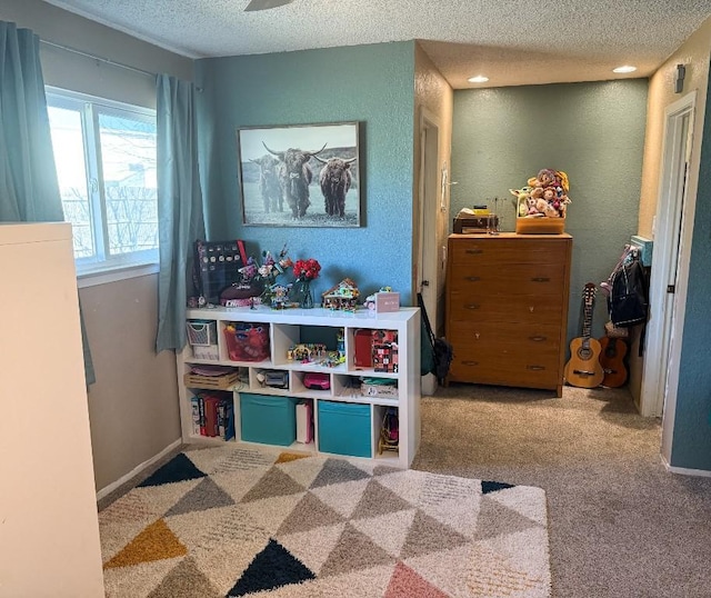 playroom featuring a textured ceiling, baseboards, and carpet floors