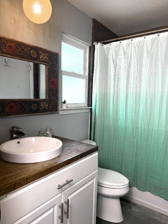 bathroom with shower / tub combo, vanity, and toilet