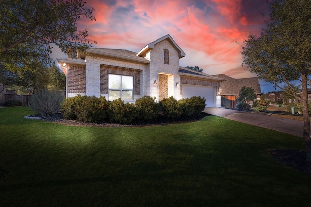 view of front facade featuring driveway, stone siding, fence, a yard, and a garage