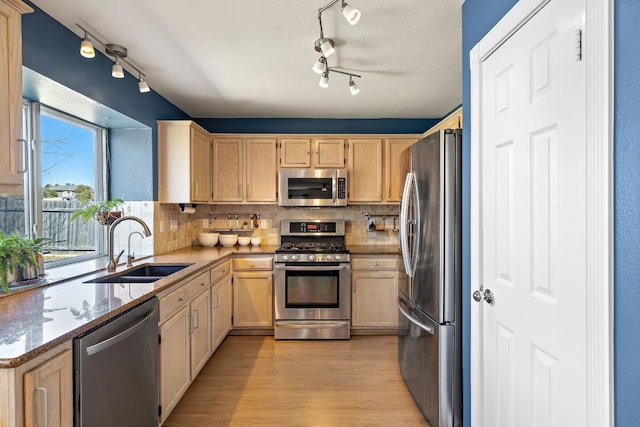 kitchen featuring a sink, decorative backsplash, light brown cabinets, and stainless steel appliances