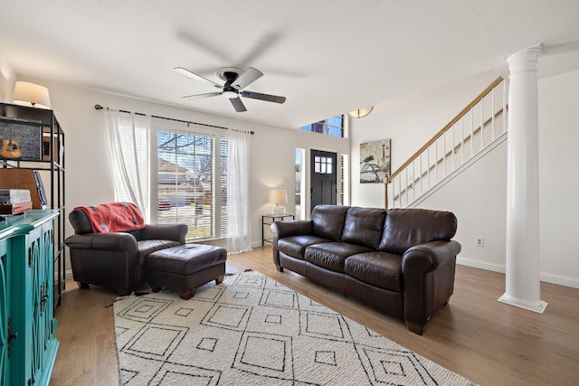 living room with a ceiling fan, stairway, decorative columns, and wood finished floors