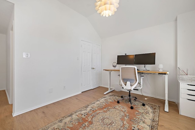 office area with baseboards, wood finished floors, and vaulted ceiling