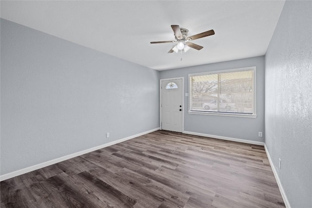 unfurnished room featuring wood finished floors, baseboards, a textured wall, and ceiling fan