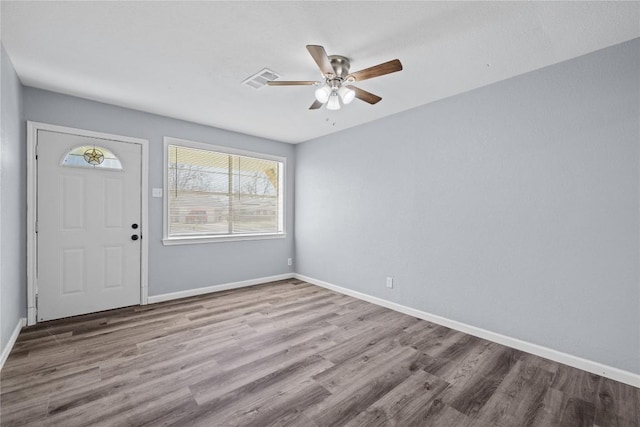 foyer featuring visible vents, wood finished floors, baseboards, and ceiling fan