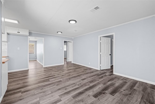 unfurnished room featuring visible vents, crown molding, baseboards, and wood finished floors