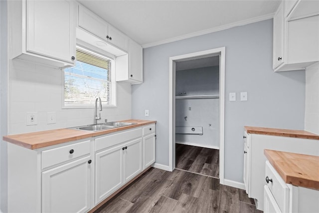 kitchen featuring a sink, dark wood-type flooring, white cabinets, and butcher block counters