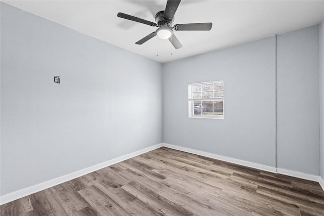 spare room with a ceiling fan, wood finished floors, and baseboards